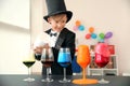 Cute little magician showing trick indoors Royalty Free Stock Photo