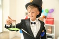 Cute little magician showing trick indoors Royalty Free Stock Photo