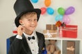 Cute little magician showing trick indoors Royalty Free Stock Photo