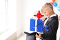 Cute little magician showing tricks with hat indoors Royalty Free Stock Photo