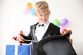 Cute little magician showing tricks with hat indoors Royalty Free Stock Photo