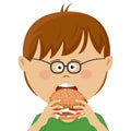 Cute little nerd boy with glasses eats burger