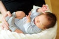 Cute little newborn baby boy sleeping in his mothers arms. Portrait of tiny new baby at home. Adorable son being held by his mommy Royalty Free Stock Photo