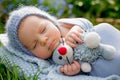 Cute little newborn baby boy, sleeping, holding cute little mouse toy Royalty Free Stock Photo