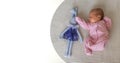 cute little newborn baby girl peacefully sleeps with toy bunny in the nursery on a white cotton bed