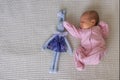 cute little newborn baby girl peacefully sleeps with toy bunny in the nursery on a white cotton bed