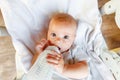 Cute little newborn girl drinking milk from bottle and looking at camera on white background. Infant baby sucking eating Royalty Free Stock Photo