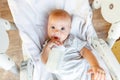 Cute little newborn girl drinking milk from bottle and looking at camera on white background. Infant baby sucking eating Royalty Free Stock Photo