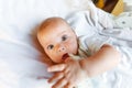 Cute little newborn girl drinking milk from bottle and looking at camera on white background. Infant baby sucking eating Royalty Free Stock Photo