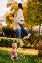 cute little one on walk with mom and dad on lawn in fall park. selective focus. Royalty Free Stock Photo