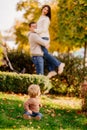 cute little one on walk with mom and dad on lawn in fall park. selective focus. Royalty Free Stock Photo