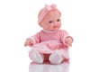 Cute little plastic baby doll with blue eyes sitting isolated o