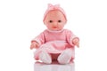 Cute little plastic baby doll with blue eyes sitting isolated o