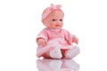 Cute little plastic baby doll with blue eyes sitting isolated o Royalty Free Stock Photo