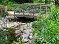 Small garden pond surrounded by colorful rocks by bridge Royalty Free Stock Photo