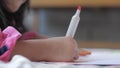 Cute little pre schooled Asian girl learning by plays and drawing with color marker on book