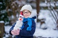 Cute little preschool girl with glasses making mini snowman. Adorable healthy happy child playing and having fun with