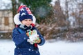 Cute little preschool girl outdoors in winter park . Adorable healthy happy child playing and having fun with snow Royalty Free Stock Photo