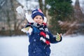 Cute little preschool girl outdoors in winter park . Adorable healthy happy child playing and having fun with snow Royalty Free Stock Photo