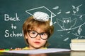 Cute little preschool kid boy in a classroom. Blackboard background. Teachers day. Kids from primary school. September 1 Royalty Free Stock Photo