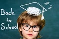 Cute little preschool kid boy in a classroom. Blackboard background. Teachers day. Kids from primary school. September 1 Royalty Free Stock Photo