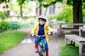 Cute little preschool kid boy riding on bicycle in park. Royalty Free Stock Photo