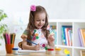 Cute little preschooler child girl drawing color pencils at home or studio