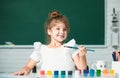 Cute little preschooler child girl drawing at school. Child girl painting on elementary school. Funny kids emotions. Royalty Free Stock Photo