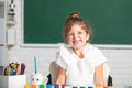 Cute little preschooler child girl drawing at school. Child girl painting on elementary school. Funny school girl face. Royalty Free Stock Photo