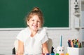 Cute little preschooler child girl drawing at school. Child girl painting on elementary school. Funny school girl face. Royalty Free Stock Photo