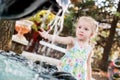 Cute little preschooler girl playing with a city fountain