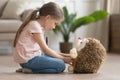 Cute little girl play doctor game with toy hedgehog