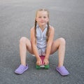 Cute little preteen girl sits on skateboard Royalty Free Stock Photo