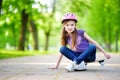 Cute little preteen girl wearing helmet sitting on a skateboard Royalty Free Stock Photo