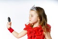 Cute little princess dressed in red on white background