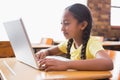 Cute little pupil looking at laptop in classroom Royalty Free Stock Photo