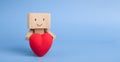 Cute little robot embracing red heart, blue panorama background