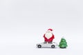 Cute little Santa claus doll on model car and Christmas tree isolate on white background Royalty Free Stock Photo