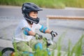 Cute little school boy child in safety helmet wearing knee pads, elbow pads and cycling gloves riding a bike on nature Royalty Free Stock Photo