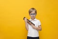 Cute little school boy in glasses holding abacus on yellow background. Mental arithmetic