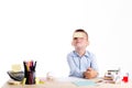 Cute little school boy with huge smile sitting at his desk on white background. Happy intelligent children in shirt with blue eye Royalty Free Stock Photo