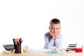 Cute little school boy with huge smile sitting at his desk on white background. Happy intelligent children in shirt with blue eye Royalty Free Stock Photo