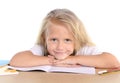 Cute little school girl happy on desk leaning in relax on book Royalty Free Stock Photo