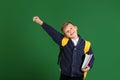 Cute little schoolboy with backpack and stationery on color background Royalty Free Stock Photo