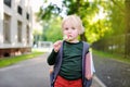 Cute little schoolboy with his backpack and lollipop. Back to school concept. Royalty Free Stock Photo