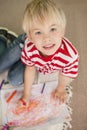 Cute little schoolboy smiling at camera while drawing