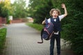 Cute little schoolboy, waving his briefcase in the schoolyard. Royalty Free Stock Photo