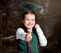 Cute little schoolgirl against chalkboard, with drawn cap Royalty Free Stock Photo