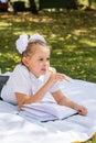 Cute little schoolgirl doing homework in a sunny autumn park. Outdoor education for children. Back to school concept. Vertical Royalty Free Stock Photo
