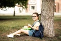 Cute little schoolgirl eating from lunch box outdoor under the tree. Food for kids Royalty Free Stock Photo